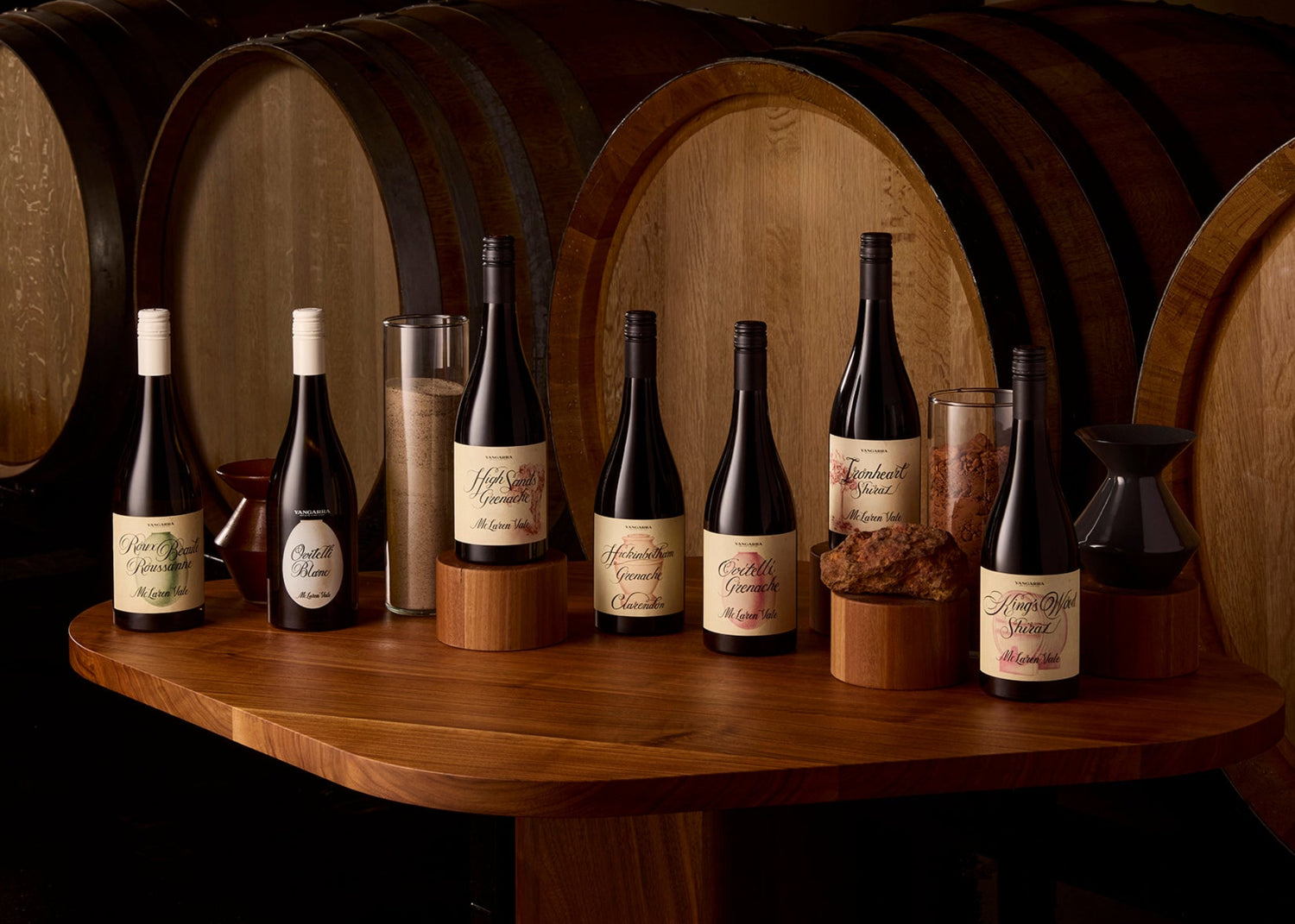 Yangarra portfolio sitting on table in front of oak barriques.