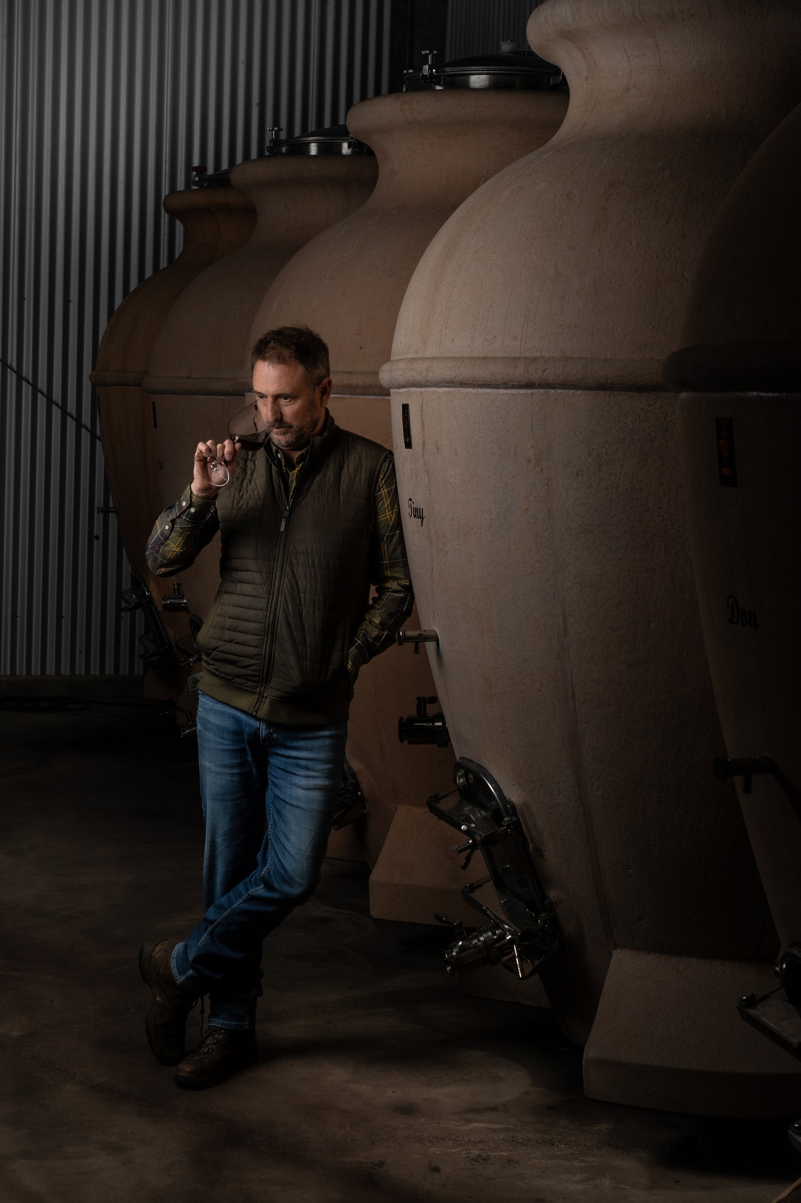 Peter Fraser standing next to large cylindrical tanks in a dimly lit room