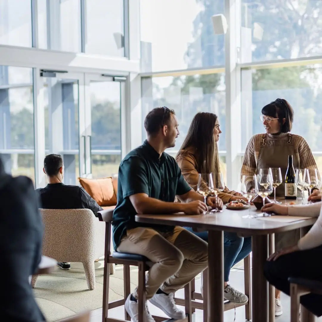 People sitting at a table in a modern cafe with large windows